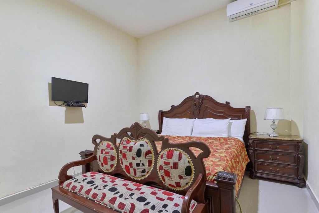 a bedroom with a bed and a chair and a tv at Hotel D'Cornelio in Santo Domingo