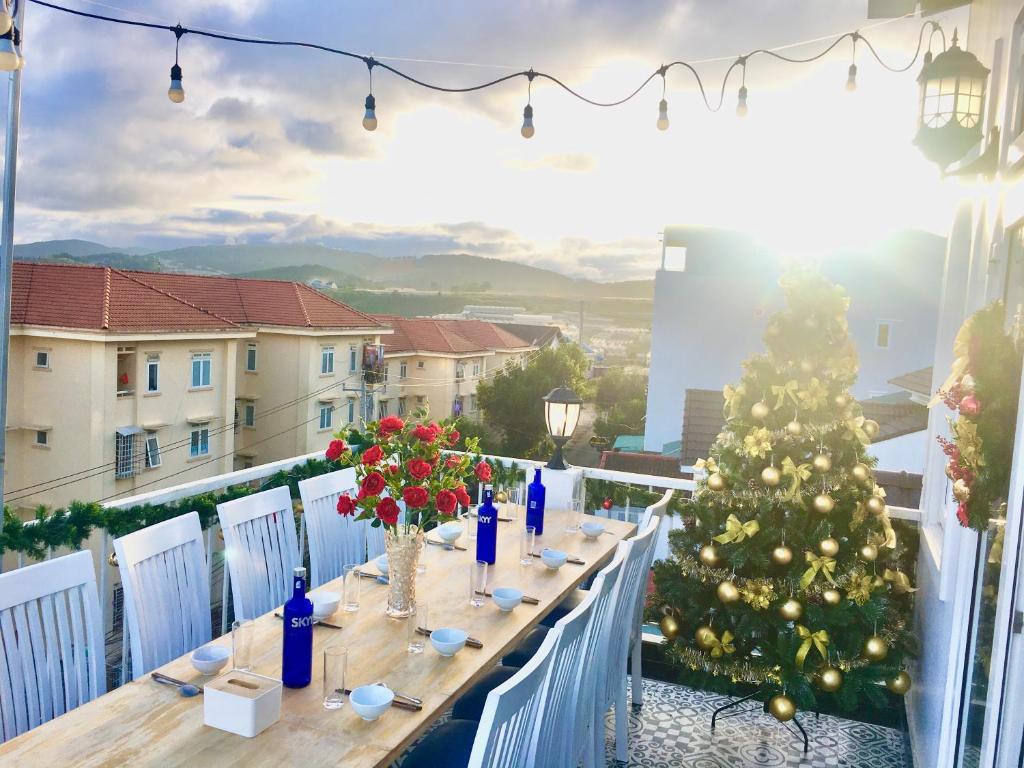 a table on a balcony with a christmas tree on it at Da Lat Mom House in Ấp Kim Thạch