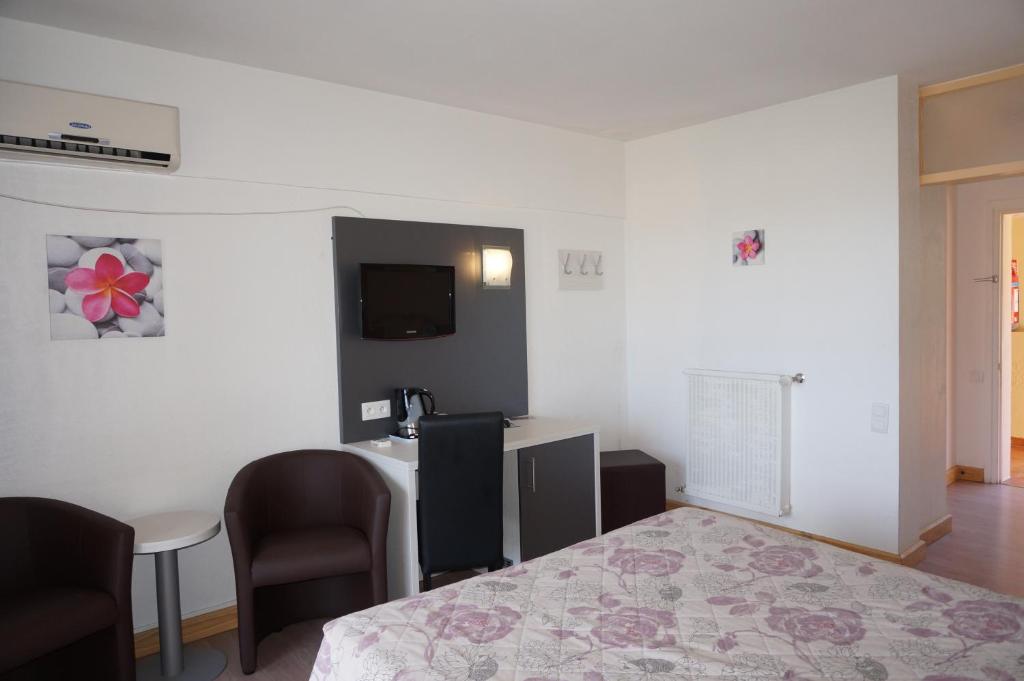 TV a/nebo společenská místnost v ubytování Logis Hotel Le Col De L'ange