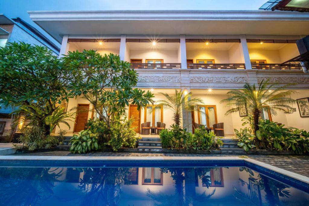 une villa avec une piscine en face d'une maison dans l'établissement The Kutaya, à Kuta