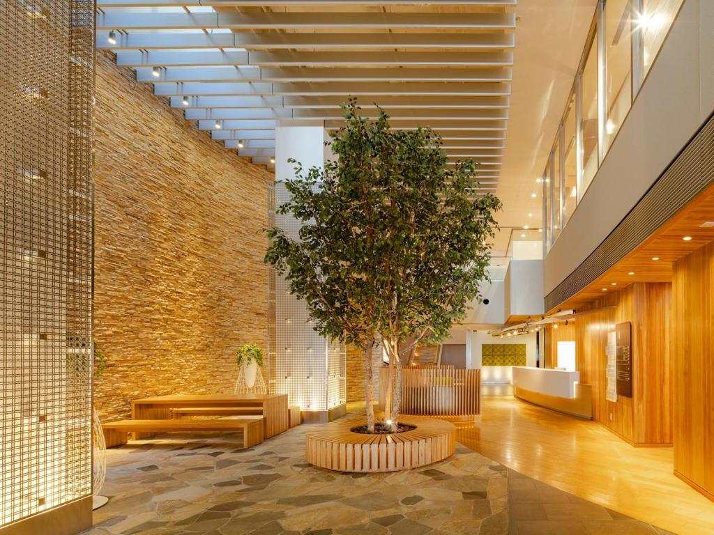 a tree in the middle of a lobby at The OneFive Sendai in Sendai