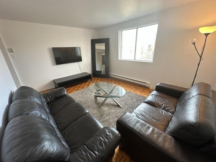 a living room with a leather couch and a table at 1 bedroom apartment - 574 in Montréal