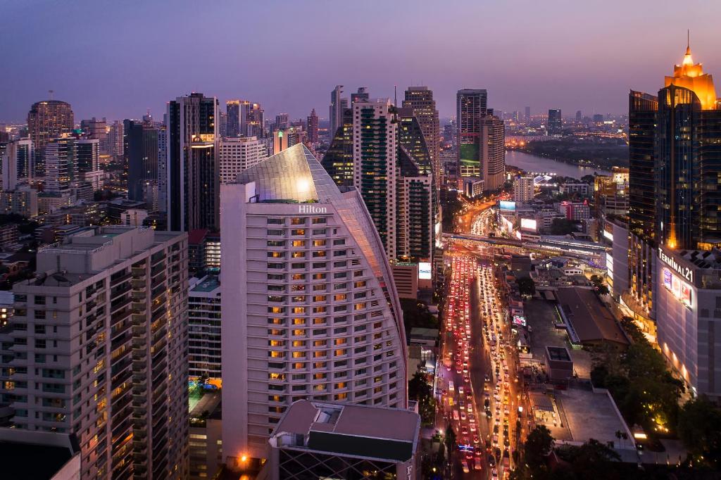 曼谷的住宿－曼谷阿索克希尔顿酒店 - Hilton Bangkok Grande Asoke，城市天际线,夜晚有很多建筑