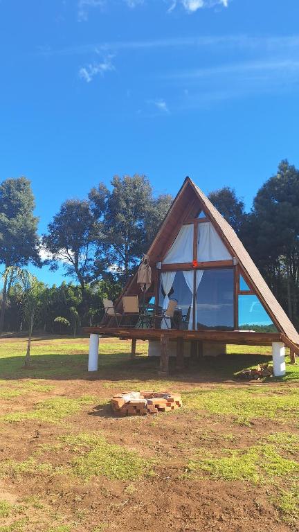 a small house with a large window on a field at Cabañas Keikary in Valle de Bravo