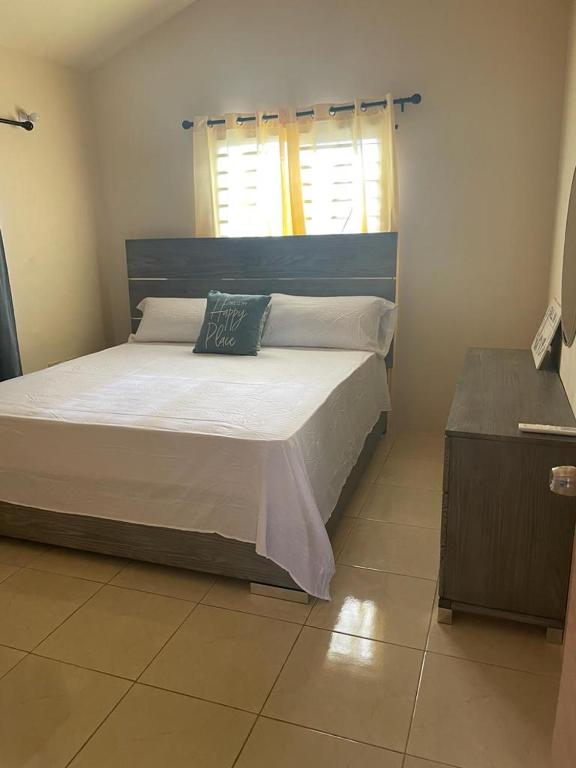 a bedroom with a large bed with a blue headboard at Finest Accommodation Lot 1577 Phoenix Park Phase 4 Portmore St Catherine 