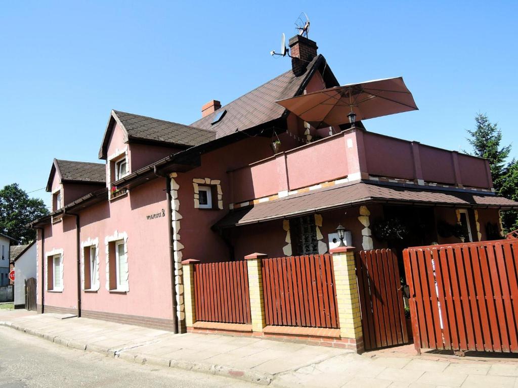 un edificio rosa con una valla delante en Comfortable holiday home for 12 people, Ko czewo, en Kołczewo