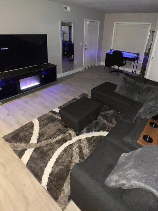 sala de estar con sofá y TV de pantalla plana en Cozy LED Condo: 2BR, 2BA Apt, en Charlotte