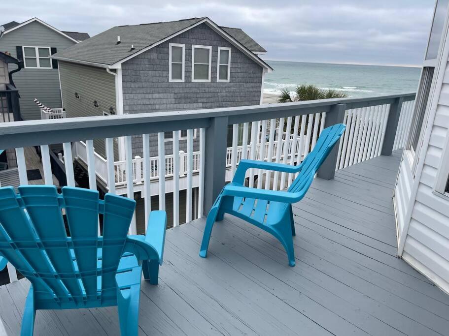 two blue chairs sitting on a deck with the ocean at Endless Summer Beach House in Myrtle Beach