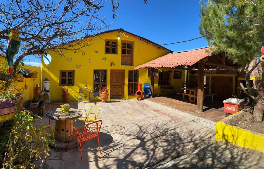 ein gelbes Haus mit einer Terrasse davor in der Unterkunft Cabaña San Juanita in Los Lirios