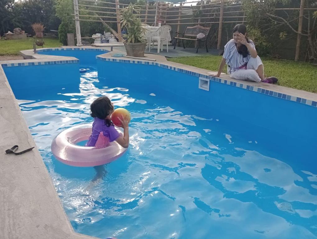 una niña en una balsa en una piscina en RENOVADA cabaña de campo y mar Deja el stress y disfruta el VERANO, en Mala