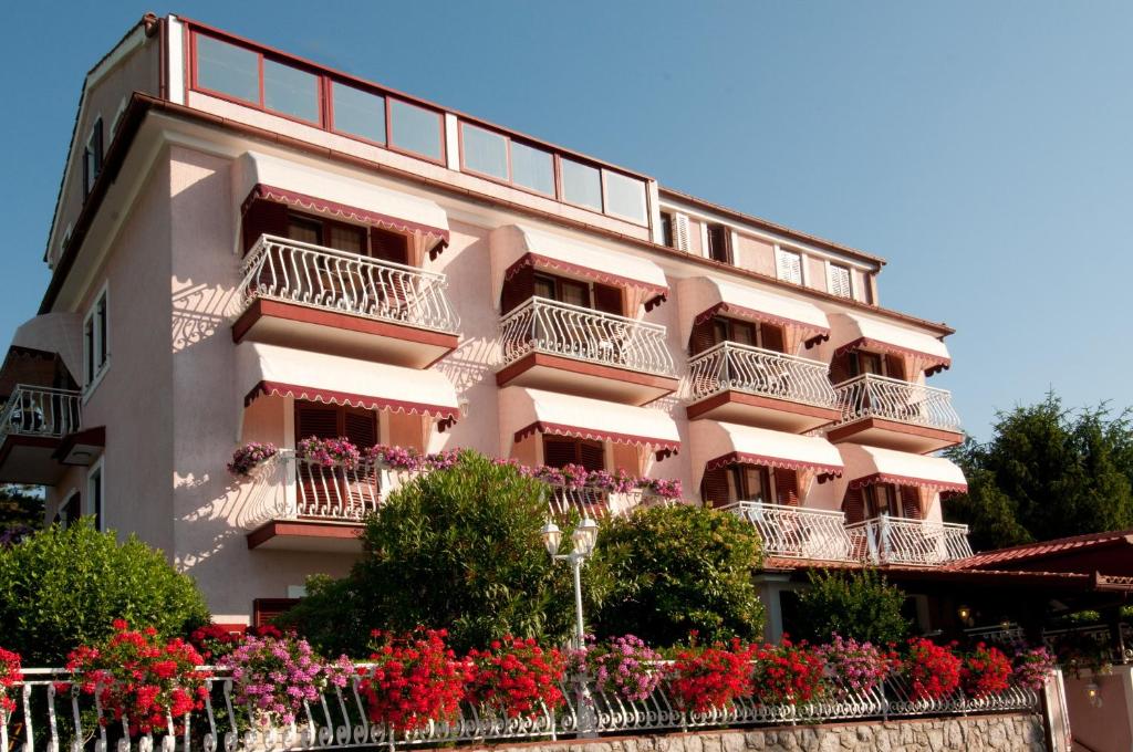 um edifício cor-de-rosa com flores à frente em Bed & Breakfast Villa Klara em Ičići