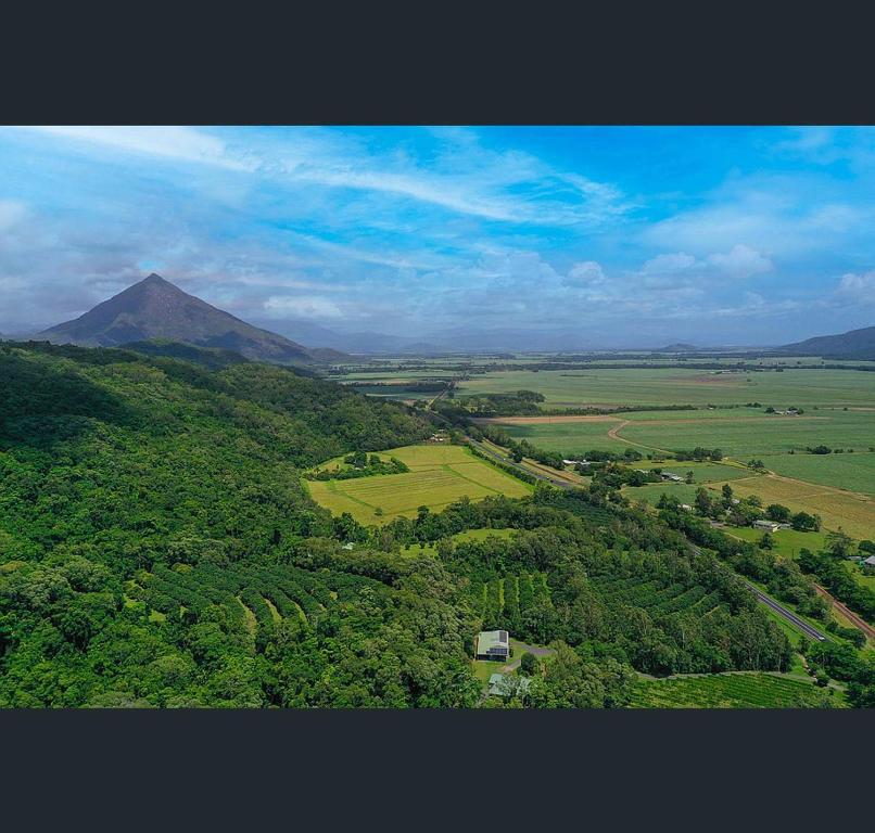 an aerial view of a lush green field with a mountain at Ahana Resort in Fishery Falls