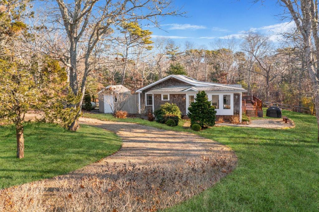 a home with a gravel driveway in front of a yard at Fresh Pond Chateau Renovated Bright and Cozy Home in Oak Bluffs