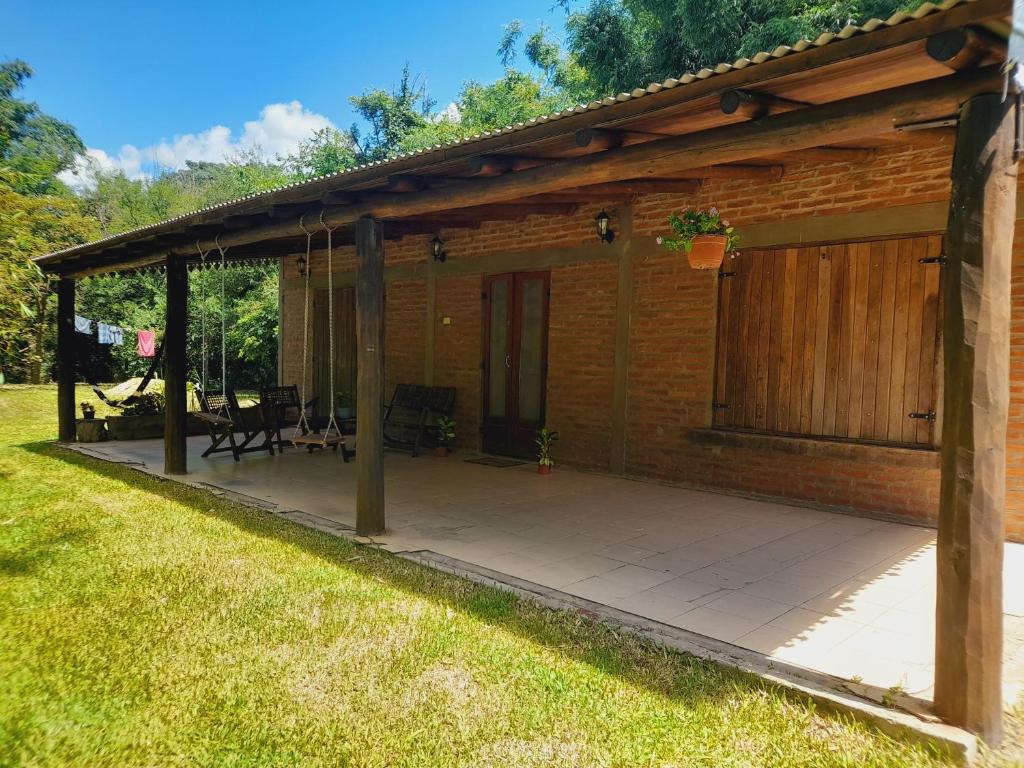 een houten paviljoen met een patio in de tuin bij Cabaña Lo de Sergio in Colonia Carlos Pellegrini