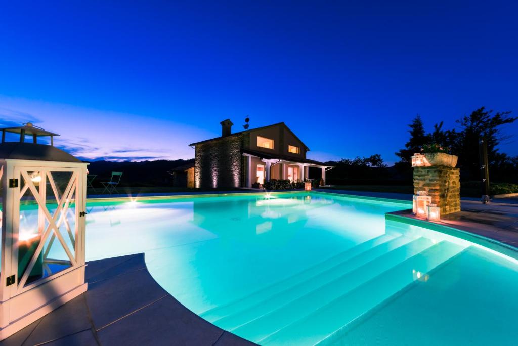 una piscina por la noche con una casa en el fondo en Chipieri, en Piobbico