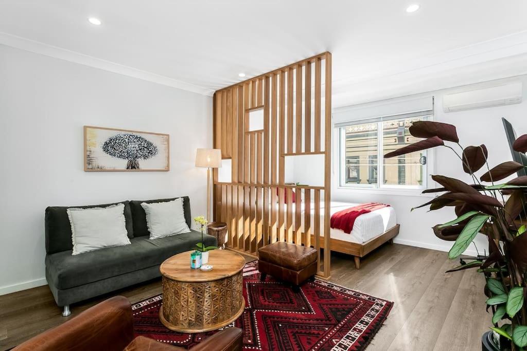 a living room with a couch and a bed at Studio Apartment in the heart of Newtown NMORE in Sydney
