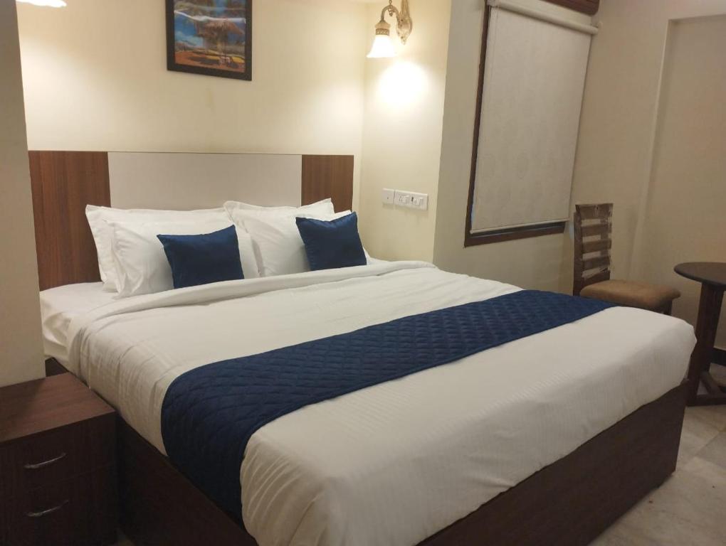 a bedroom with a large bed with blue and white pillows at A.R Residency in Chennai