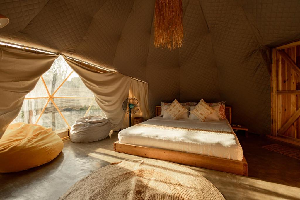 a bedroom with a bed in a tent at Domes and Dreams Lio Glamping in El Nido