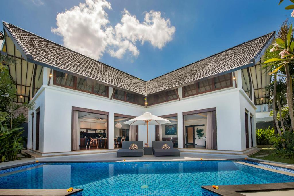 an exterior view of a villa with a swimming pool at Villa Tramonto By Le Cielo in Canggu