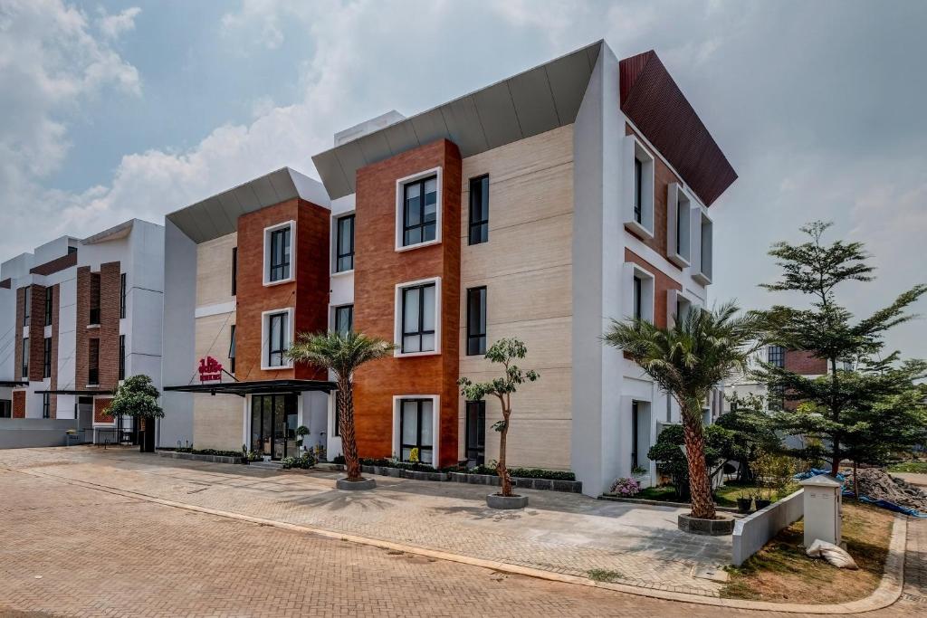 an exterior view of a building with palm trees at OYO Life 93289 Jelita Residence 2 in Semarang