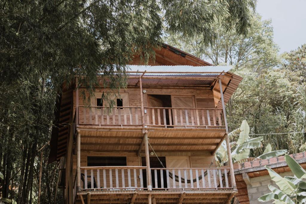 a wooden house with a balcony in the trees at Finca el Moral in Medellín