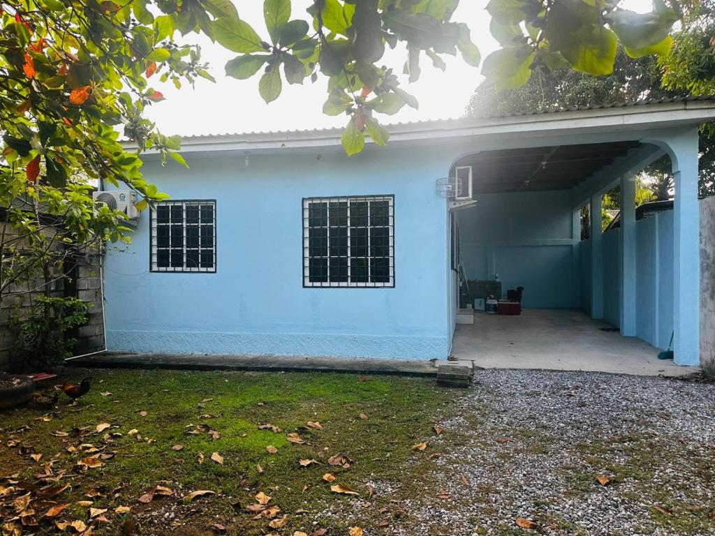 a house with a blue wall and a garage at Casa en Puero Cortes in Puerto Cortés