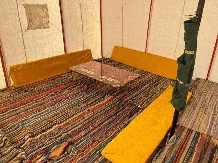 an empty bed in a room with a carpet at Nuba falcon in Aswan