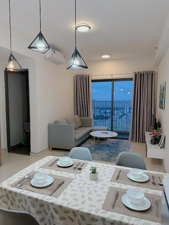 een woonkamer met een tafel en stoelen en een bank bij Luxury apartment in Masteri Thao Dien Free Gym, Pool in Ho Chi Minh-stad