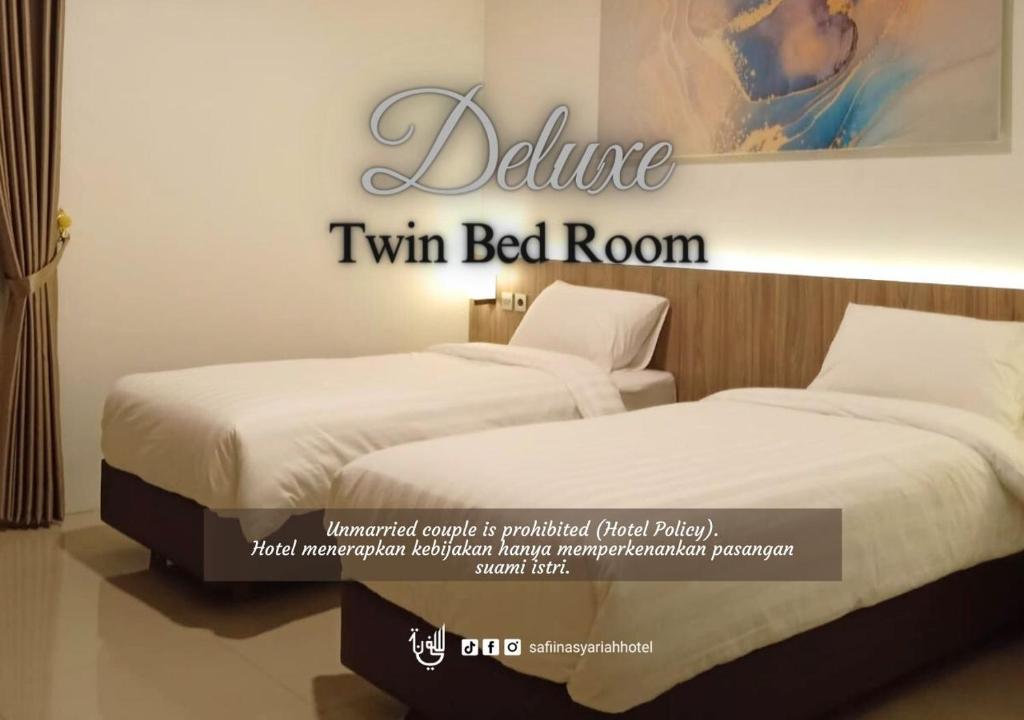 Postel nebo postele na pokoji v ubytování The Safiina Point Syariah Hotel