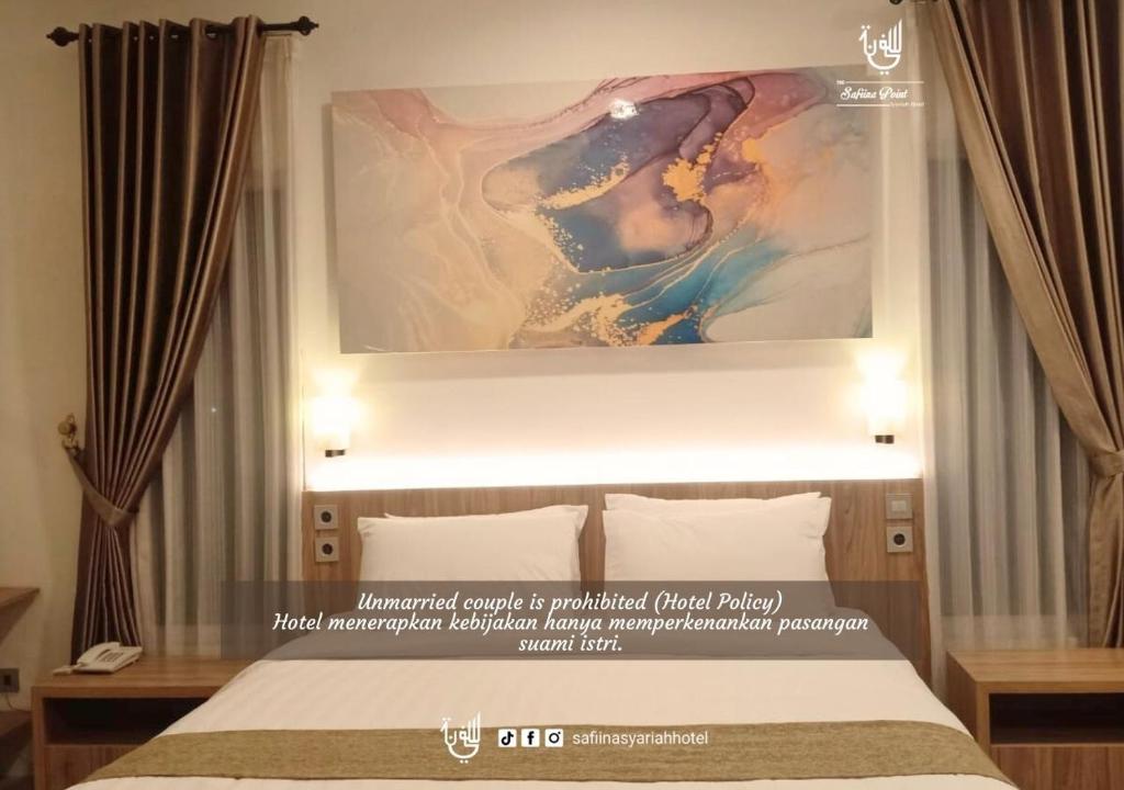 Postel nebo postele na pokoji v ubytování The Safiina Point Syariah Hotel