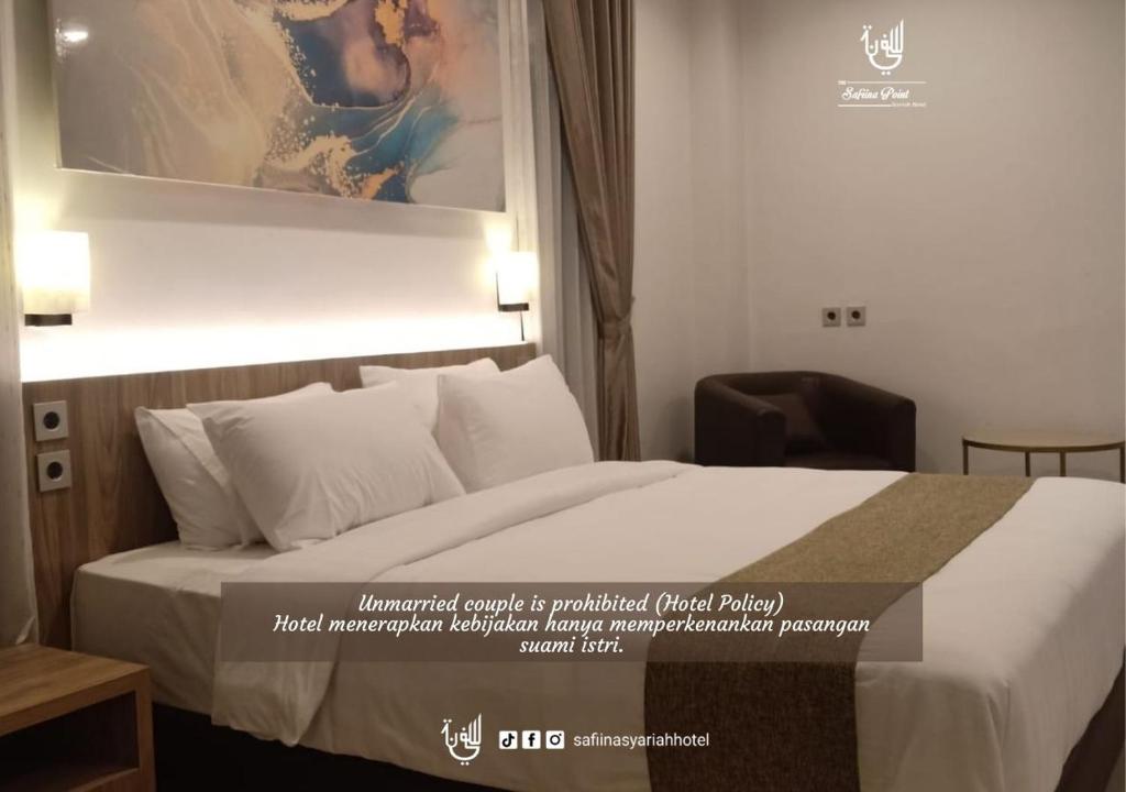 Postel nebo postele na pokoji v ubytování The Safiina Point Syariah Hotel