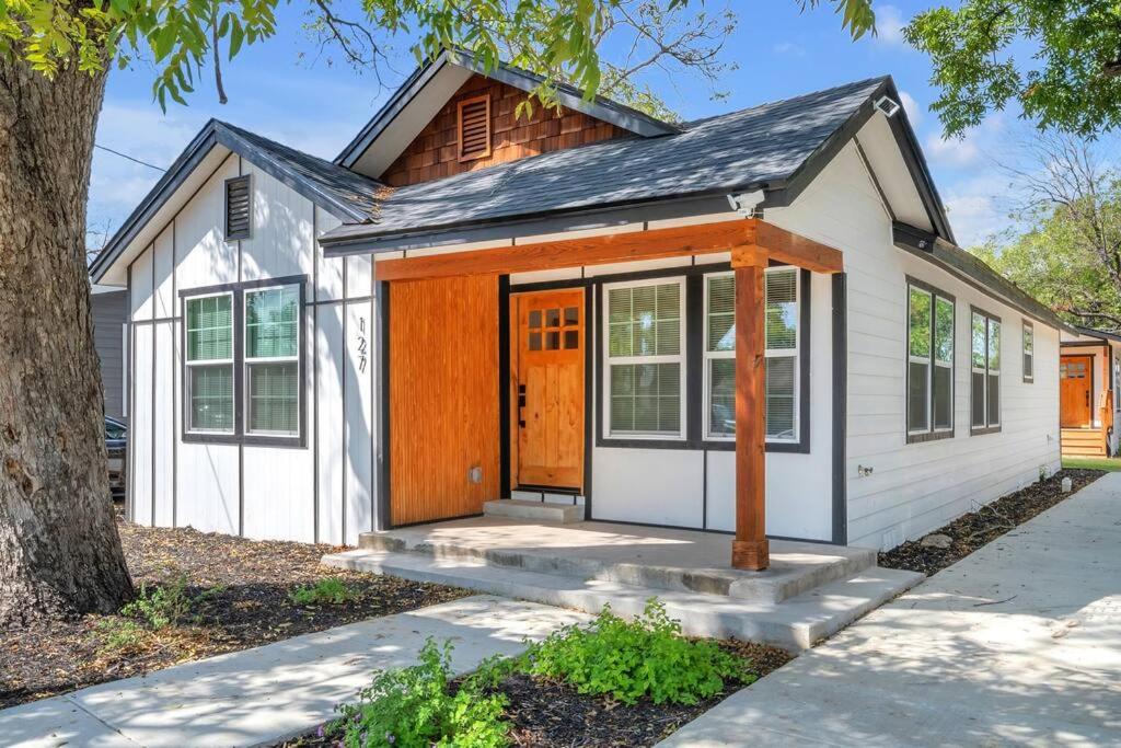 Casa blanca pequeña con puerta de madera en Urban Sanctuary, en San Antonio
