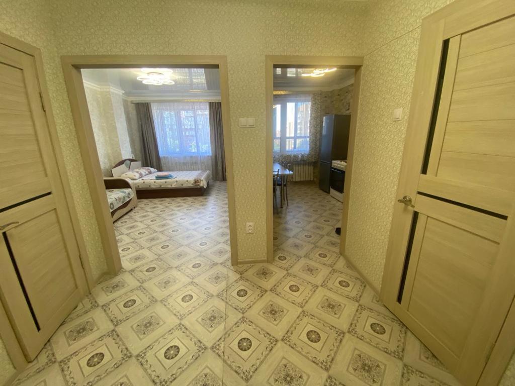 een open deur naar een kamer met een woonkamer bij Уютная однушка в новостройке in Karagandy