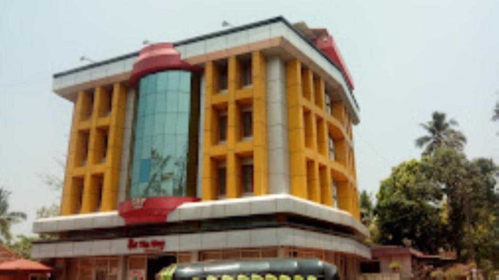 a large yellow building with a lot of windows at Sap Inn Pallom in Kottayam
