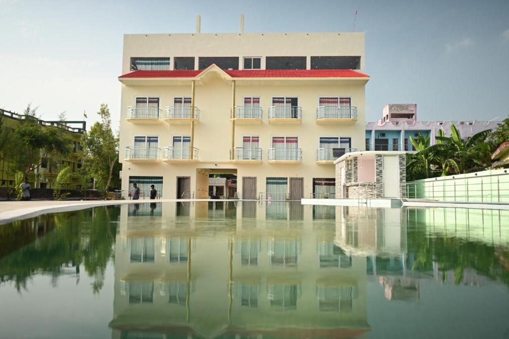 a building with a pool of water in front of it at I Light Beach Resort in Mandarmoni