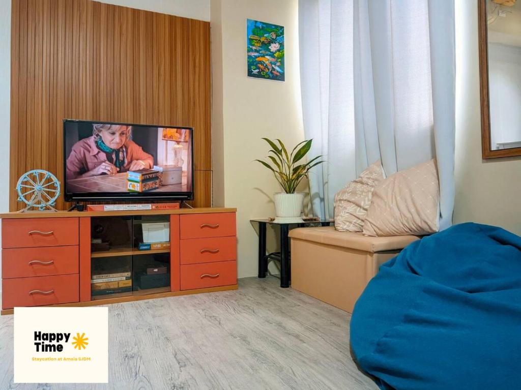 sala de estar con TV en un centro de entretenimiento de madera en Affordable Vacation Rental in San Jose Del Monte Bulacan, en Tunkong Manga