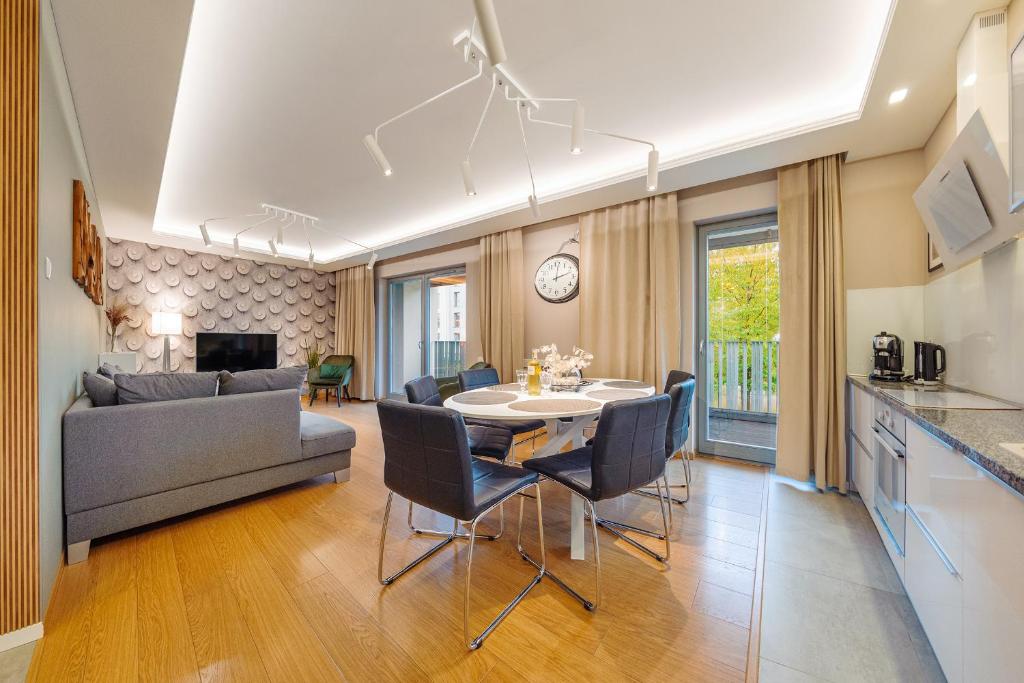 een keuken en een woonkamer met een tafel en stoelen bij Rio de Mare - Nadmorze Apartments in Gdańsk