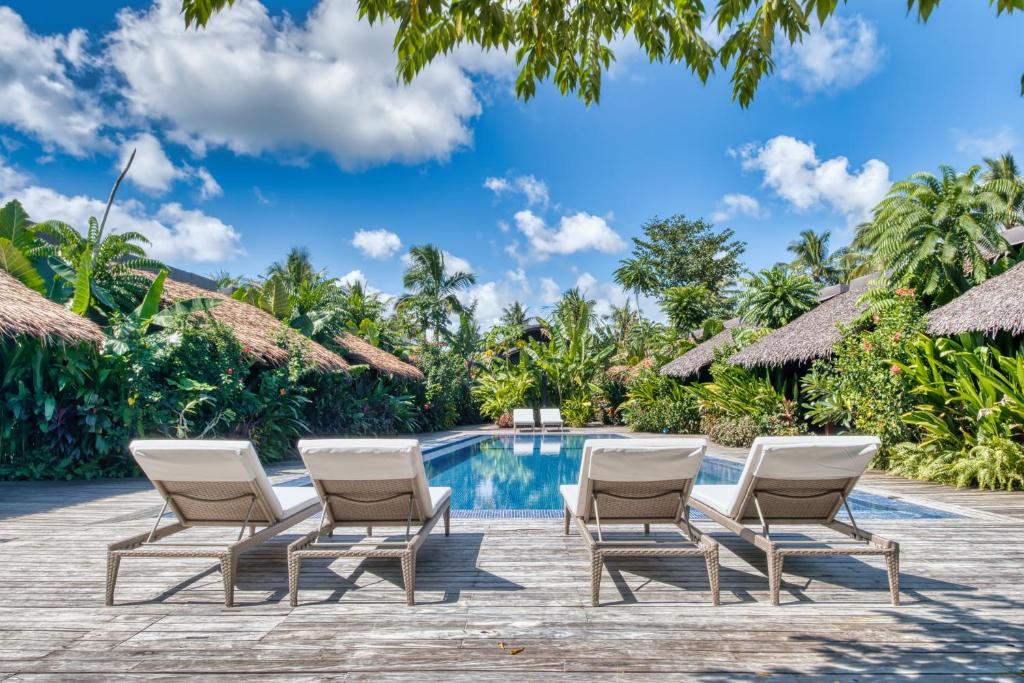 een groep stoelen en een zwembad in een resort bij Kajali Siargao in General Luna