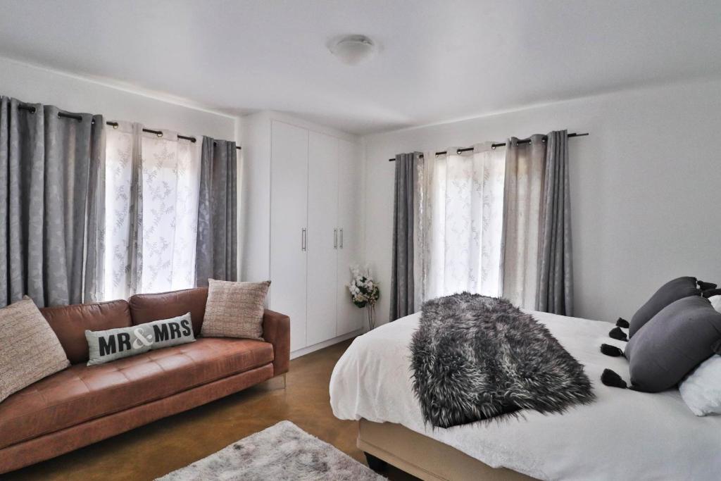 uma sala de estar com uma cama e um sofá em Fran's Oasis na Cidade do Cabo