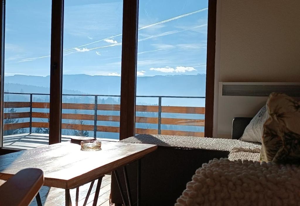 a room with a table and a balcony with a view at Zlatni Hrast in Pale