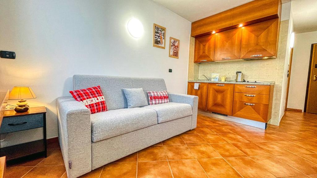 ein Wohnzimmer mit einem Sofa und einer Küche in der Unterkunft Appartamento Smith Dogliani - Affitti Brevi Italia in Bardonecchia