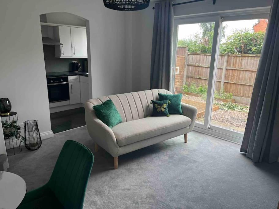 uma sala de estar com um sofá e uma cozinha em Nuneaton-GE Hospital 3 mins away em Nuneaton