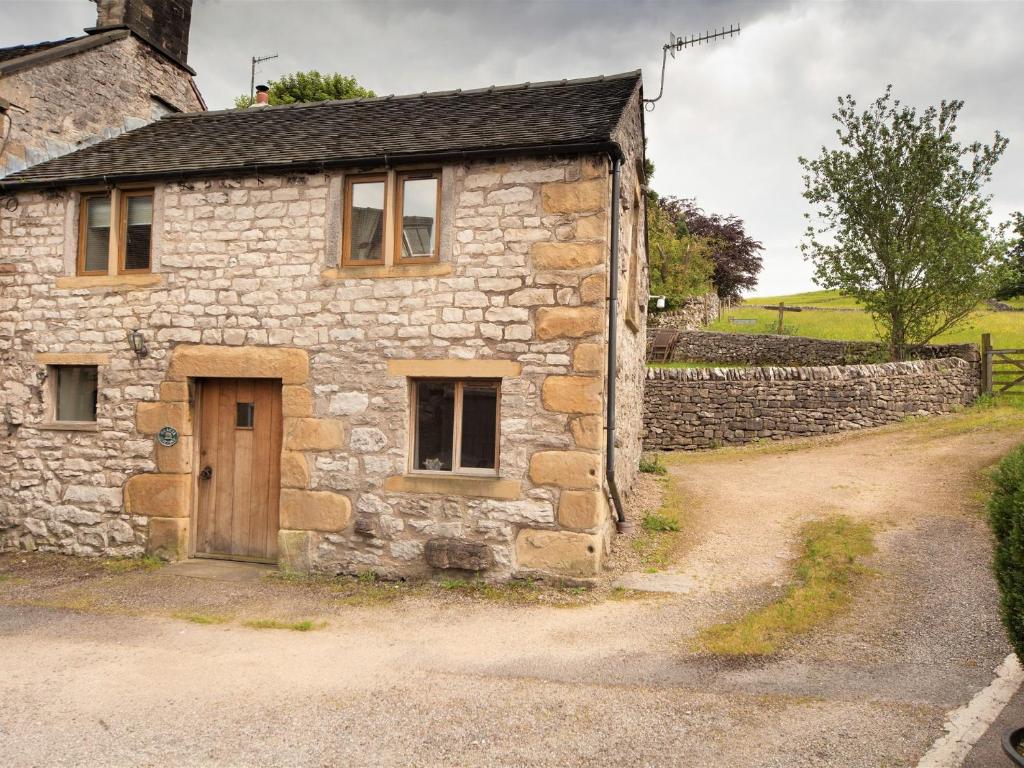 an old stone house with a wooden door on a dirt road at 2 Bed in Hartington 54214 in Hartington
