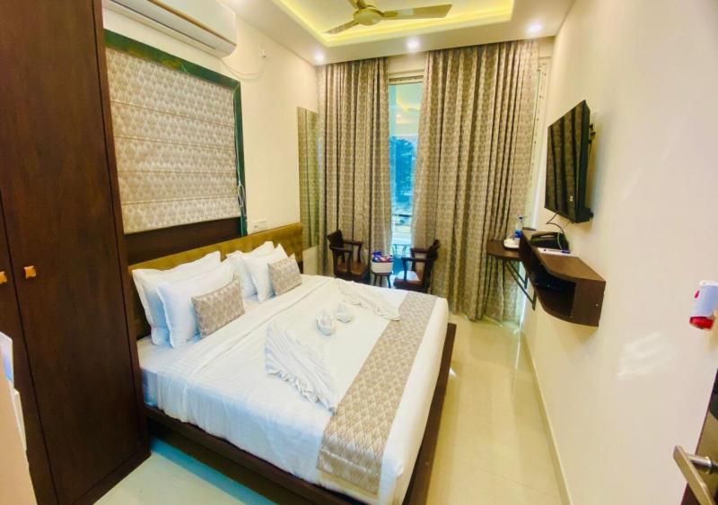 a bedroom with a large bed with a window at One Infinity Residency in kolkata