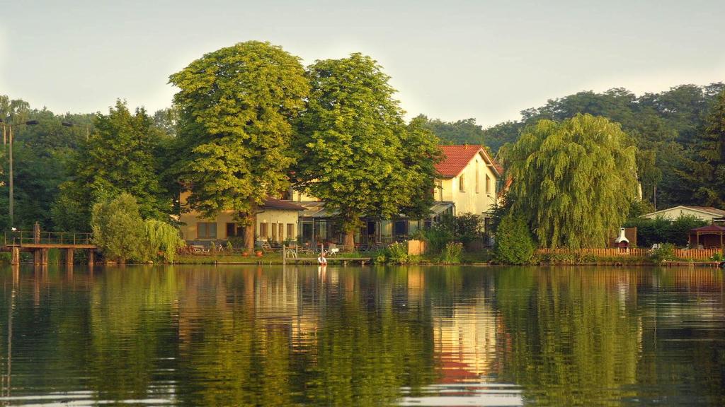 um grupo de casas na margem de um lago em Hotel Fährhaus GmbH em Woltersdorf