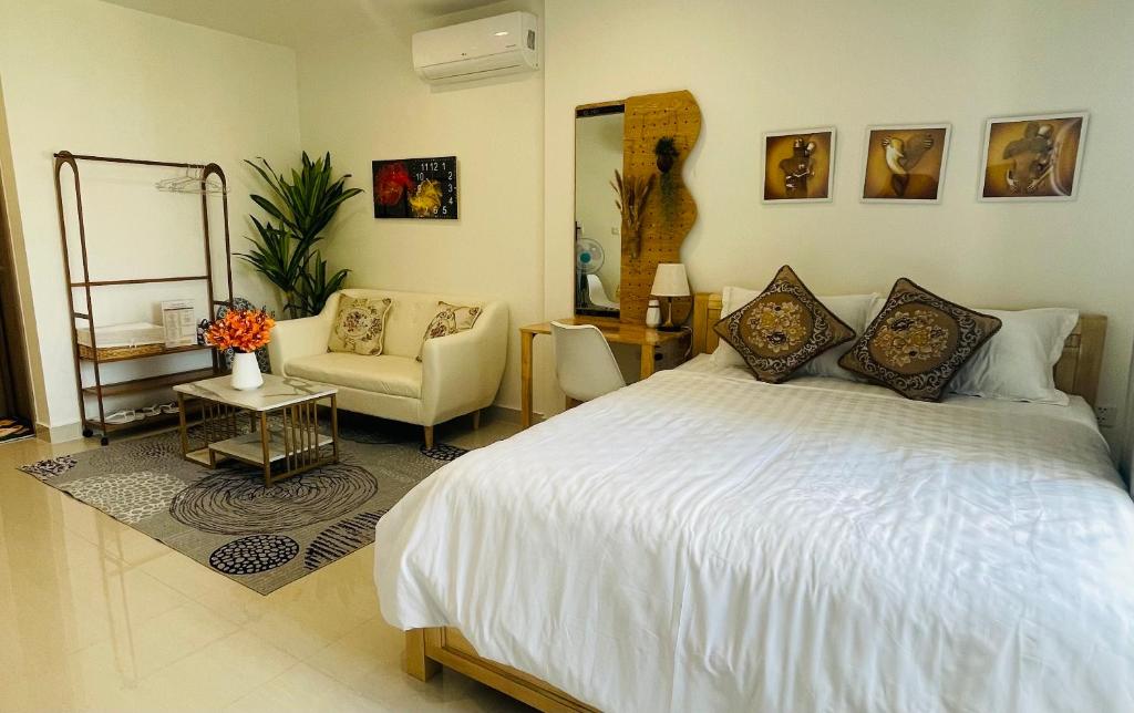 a bedroom with a large white bed and a chair at Căn hộ studio Vinhome grand park Quận 9 in Long Bình