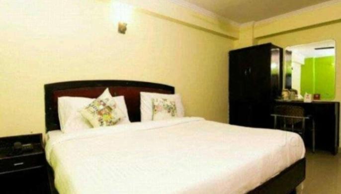 ein Schlafzimmer mit einem großen weißen Bett in einem Zimmer in der Unterkunft Hotel madhava in Sītāpur