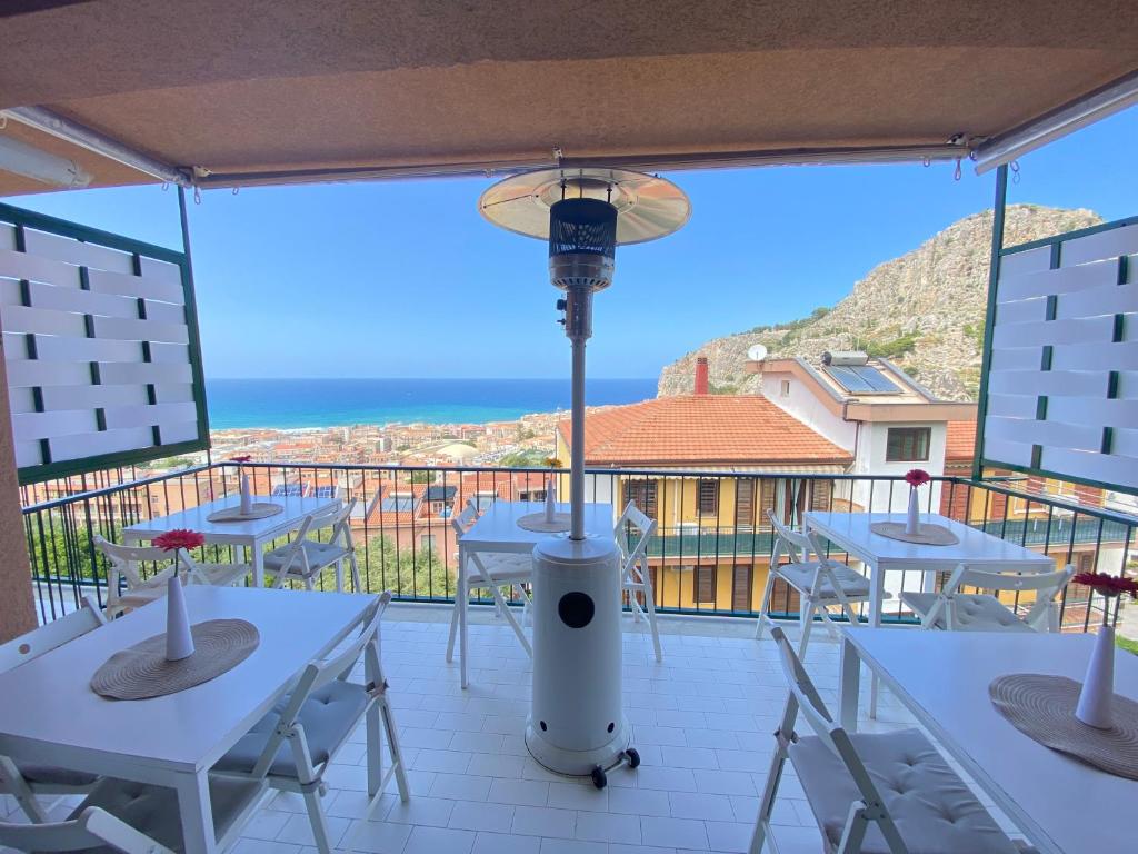 a balcony with tables and chairs and a view of the ocean at Ma&Mi Guest House in Cefalù
