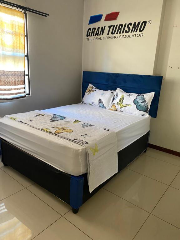 a bed with a blue headboard in a room at M D J Hayfields Guest House in Pietermaritzburg