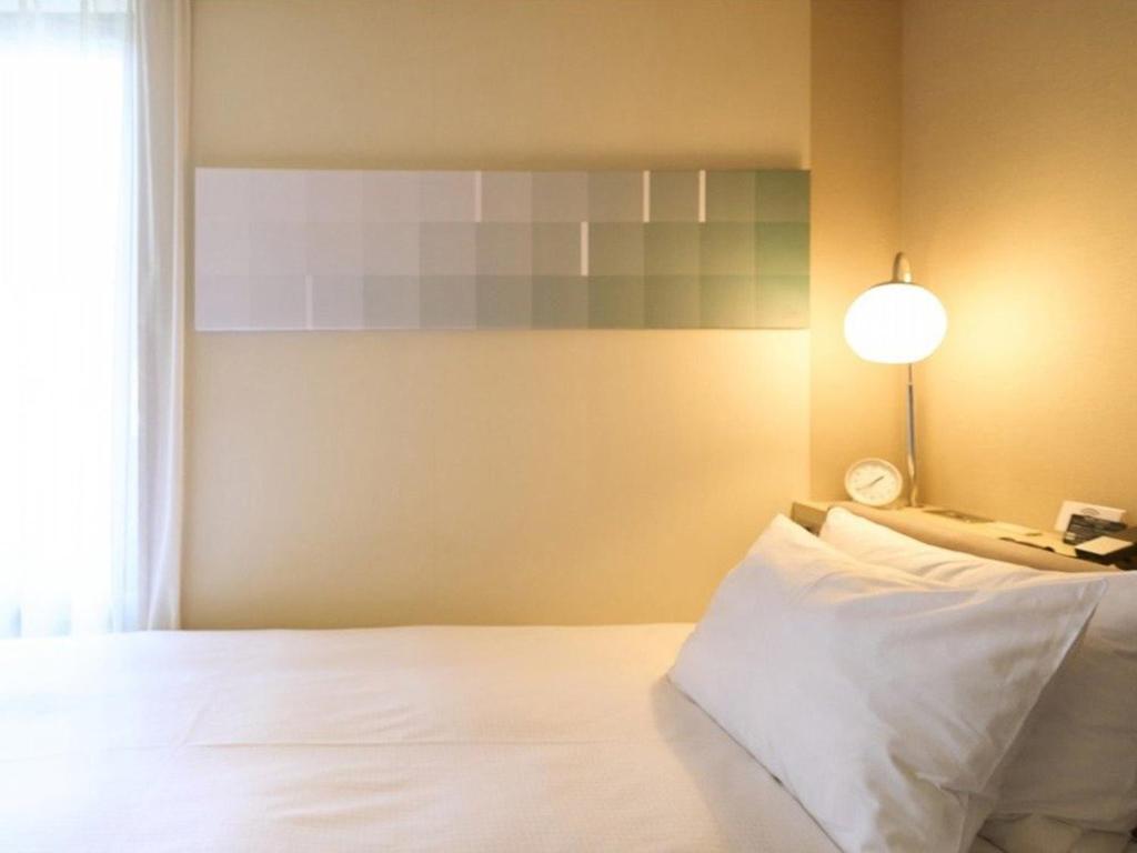 Postel nebo postele na pokoji v ubytování Hotel Resol Ikebukuro
